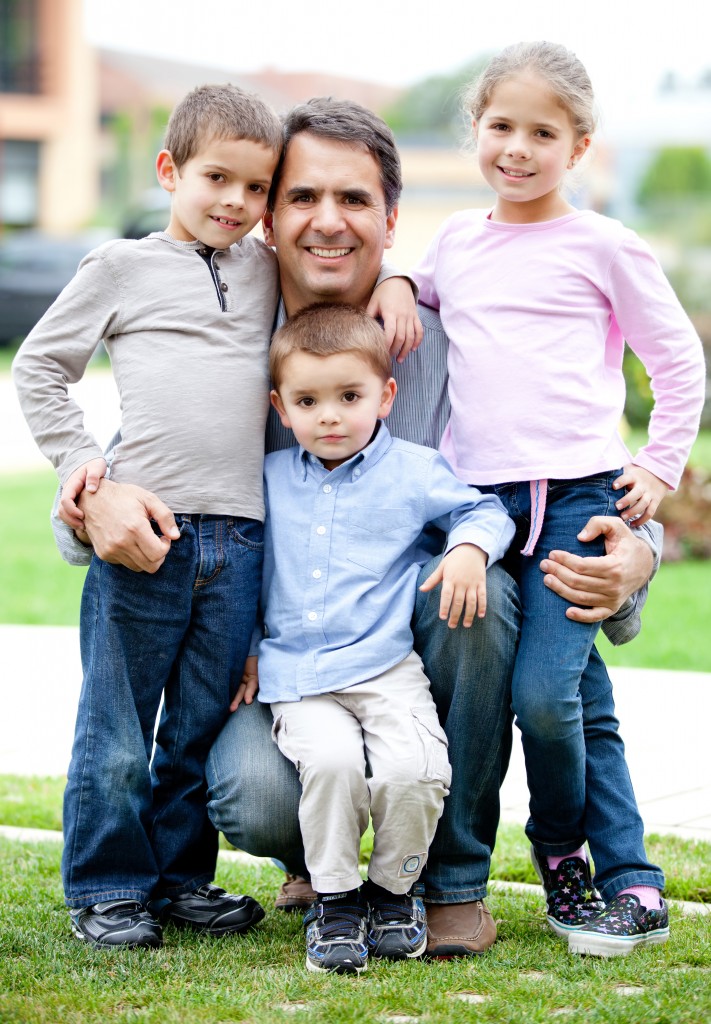 Lovely family portrait of father with his children smiling outdoors